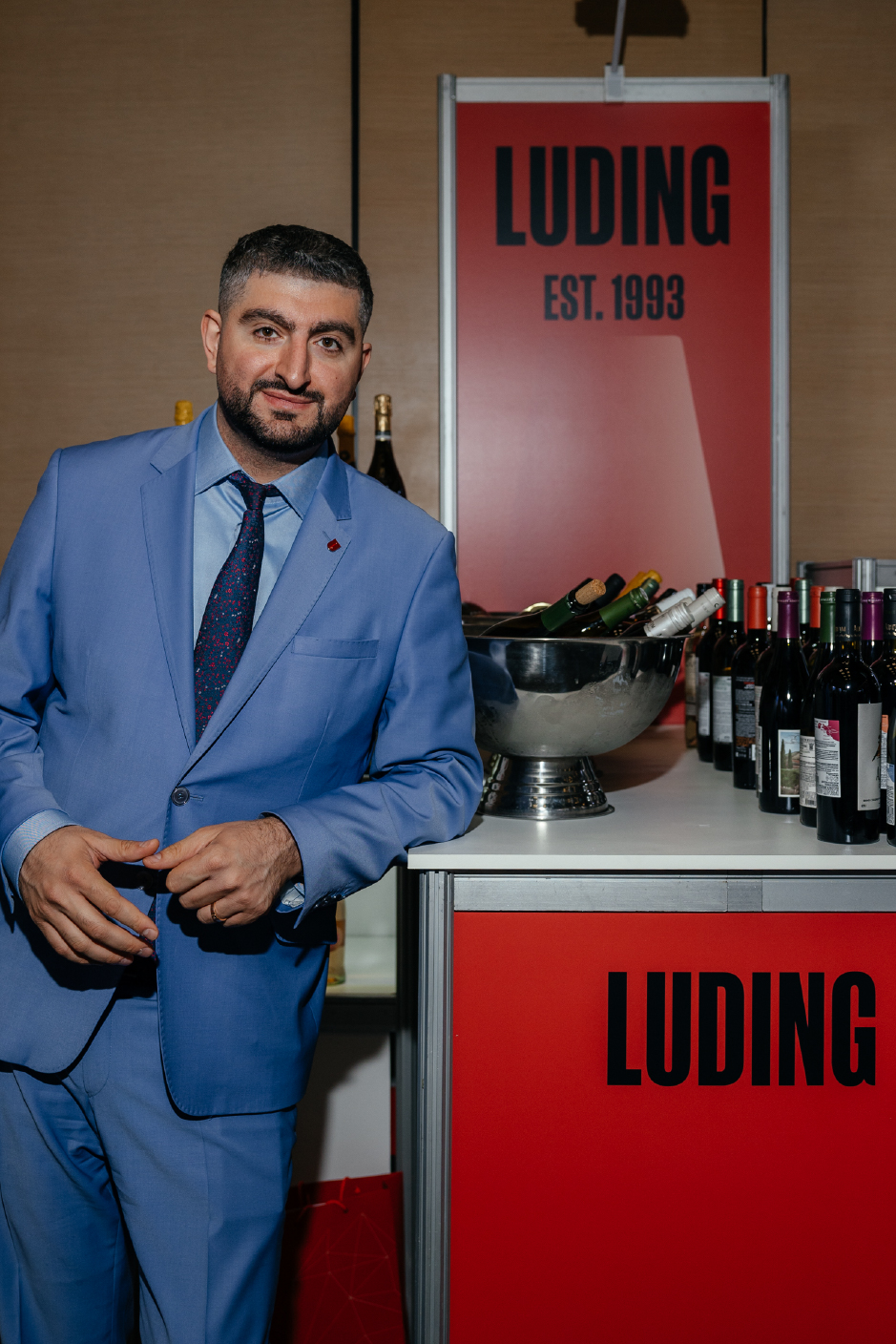 Председатель совета директоров LUDING (ЛУДИНГ) Эрнест Хачатурян около стенда с вином и крепкими напитками из портфолио компании